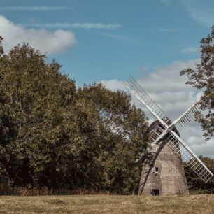 2 images of the windmill framed by trees